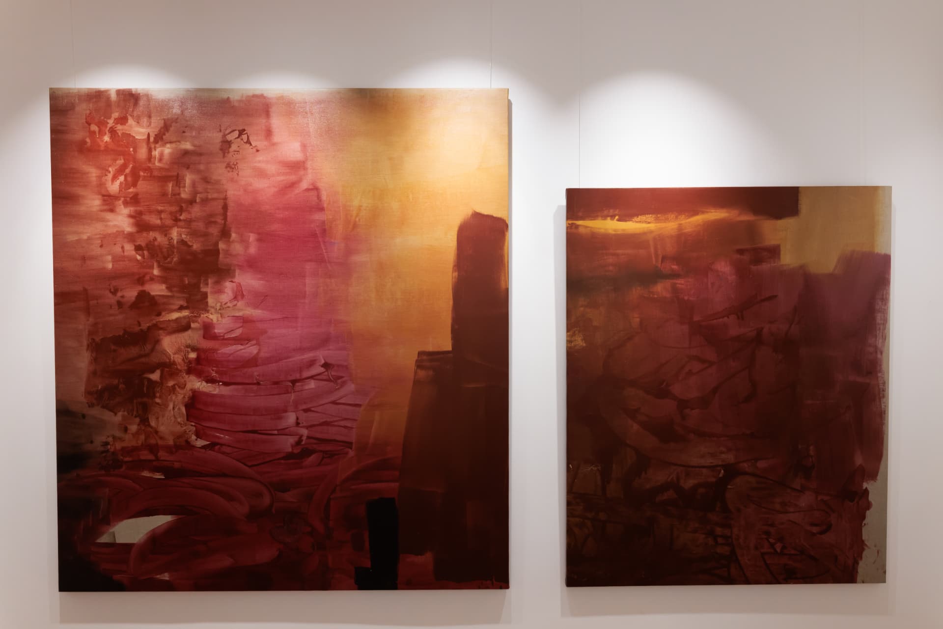 Two crimson and gold paintings side by side in the gallery