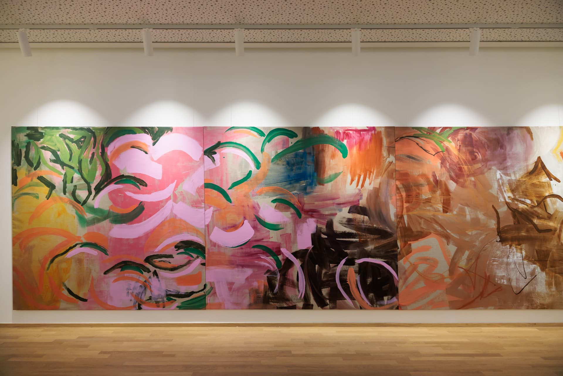 Three-panel painting in pink, green and ochre on the gallery wall